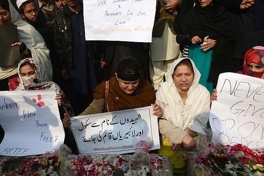 Pakistan civil society activists hold placards during a protest against the Taleban militants' attack on an army-run school in Peshawar on Dec 18, 2014. -- PHOTO: AFP