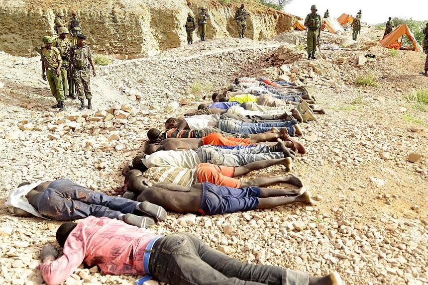 Members of the military gather near the bodies of some 36 quarry workers killed by Shebab rebels on Dec 2, 2014 near the town of Mandera, northern Kenya, along the border with Somalia. A Finnish court on Friday handed suspended jail terms to four men