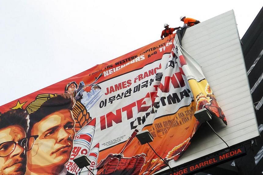 Workers remove the poster for The Interview from a billboard in Hollywood, California, Dec 18, 2014.&nbsp;A US investigation into the hack of Sony's computer system has determined that North Korea was behind the operation with a possible Chinese link