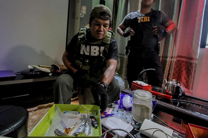 National Bureau of Investigation operatives inspect confiscated materials inside the Bilibid prison in Muntinlupa, south of Manila on Dec 16, 2014. -- PHOTO: AFP