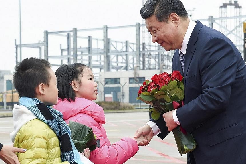 Chinese President Xi Jinping shakes hands with a child as he receives a bouquet upon arriving in Macau to celebrate the 15th anniversary of its handover to the mainland on Dec 19, 2014. -- PHOTO: REUTERS