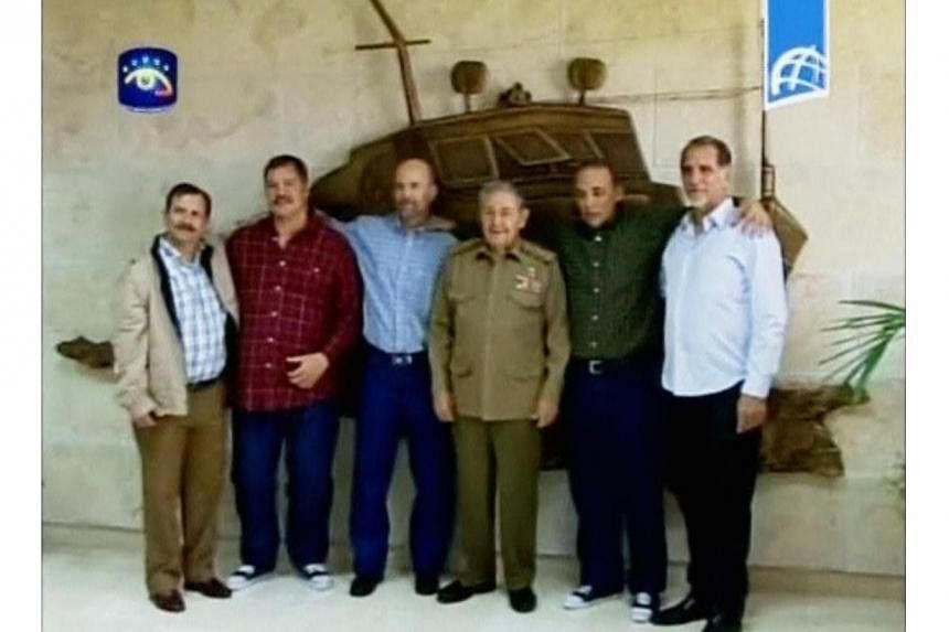 Cuban President Raul Castro (C) poses with three Cuban intelligence agents released by the U.S. government, after they returned to Havana on Wednesday, in this image taken from government television. The President seems to have scored a diplomatic tr
