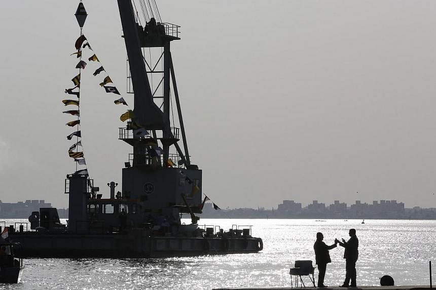 People talk as they stand looking over the Suez Canal in Ismailia city on Nov 13, 2014.&nbsp;An Egyptian court has jailed a Suez Canal shipping services manager for 10 years on charges of spying for Israel about naval movements through the strategic 