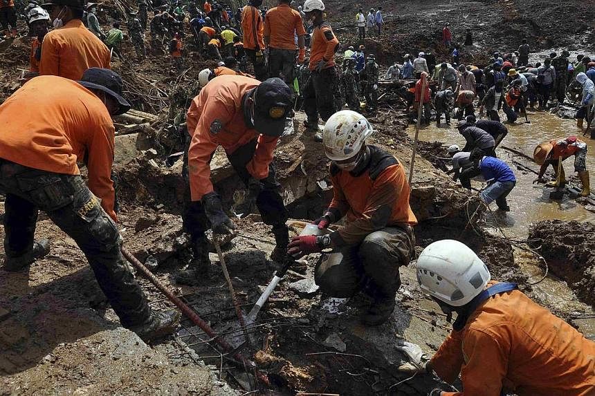 Rescue team members and soldiers use shovels during the search for landslide victims who are still buried in Sampang village in Banjarnegara, in this Dec 16, 2014 photo taken by Antara Foto.&nbsp;Indonesian rescuers on Sunday, Dec 21, ended their sea