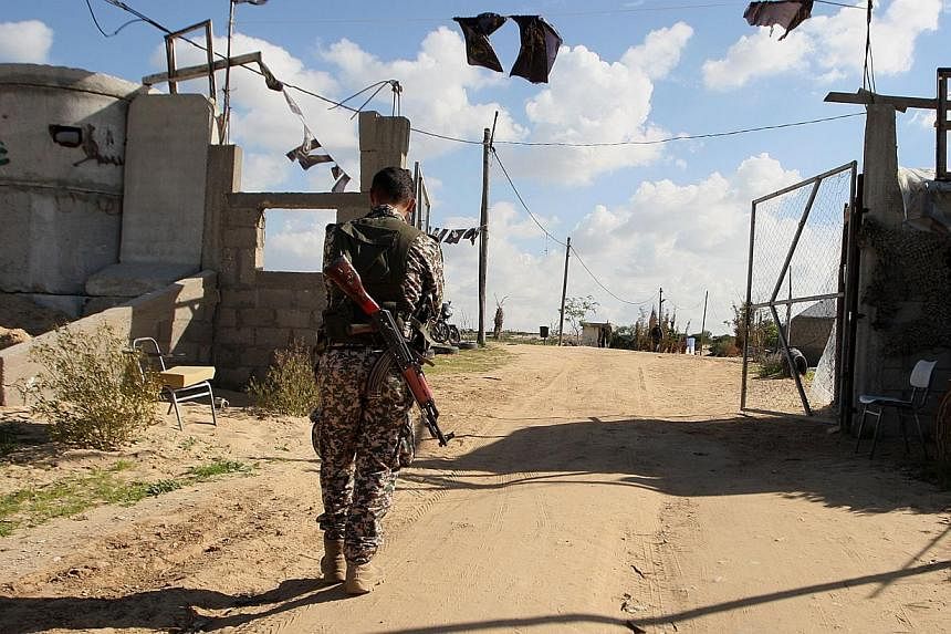 A Palestinian militant from the Islamic Jihad armed wing, the Al-Quds Brigades, walks near a military post on Dec 20, 2014 in Khan Yunis, in the southern Gaza Strip. Israeli jets struck targets in the southern Gaza Strip, witnesses and the army said 