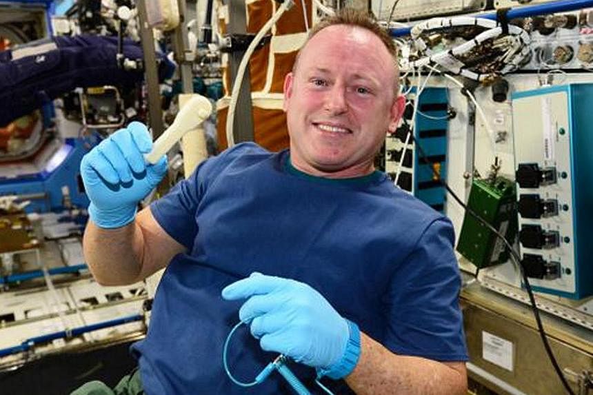 An undated photo courtesy of Nasa obtained Dec 20, 2014, shows space station commander Butch Wilmore as he holds up the ratchet after removing it from the print tray. -- PHOTO: AFP