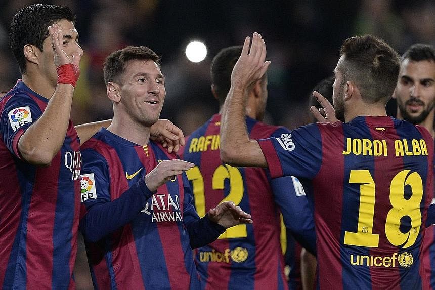 Barcelona's Argentinian forward Lionel Messi (second left) is congratulated by his teammates after scoring during the Spanish league football match FC Barcelona versus Cordoba CF at the Camp Nou stadium in Barcelona on Dec 20, 2014. Barcelona won 5-0