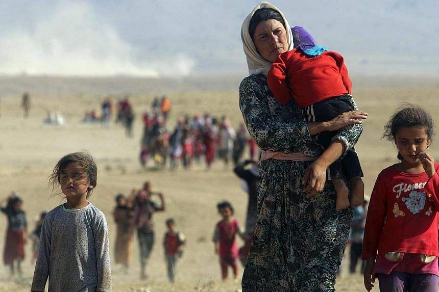 Displaced people from the minority Yazidi sect, fleeing violence from forces loyal to the Islamic State in Sinjar town, walk towards the Syrian border on Aug 11, 2014.&nbsp;Iraqi Kurdish leader Massud Barzani hailed victories over the Islamic State i