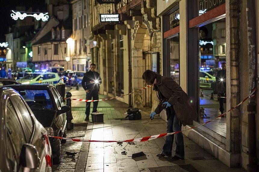 A policewoman collects evidence on Dec 21, 2014 in Dijon on the site where a driver shouting "Allahu Akbar" ("God is great") ploughed into a crowd injuring 11 people. -- PHOTO: AFP&nbsp;