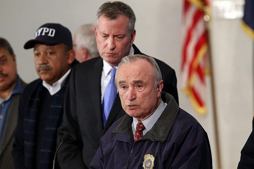New York City Police Commissioner William J. Bratton is joined by Mayor Bill de Blasio at a news conference at Woodhull Hospital following the killing of two New York City police officers on Dec 20, 2014 in New York City. -- PHOTO: AFP