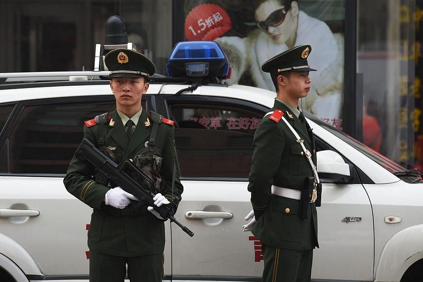 Chinese paramilitary police officers watch over pedestrians in the Wangfujing shopping district in Beijing on Oct 24, 2014.&nbsp;The mother of a man executed 20 years ago for a murder to which another person later confessed appeared in a Chinese cour