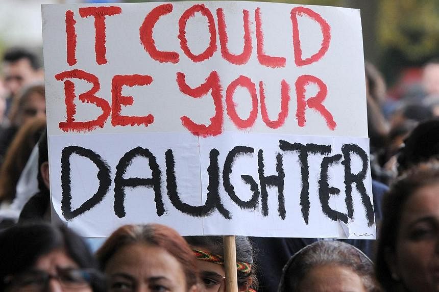 A Kurd Yazidi holds a sign reading "it could be your daughter" while demonstrating in Oldenburg, northern Germany, on Oct 25, 2014.&nbsp;A German government minister said on Monday, Dec 22, 2014, that Berlin aimed to set up a trauma centre for victim