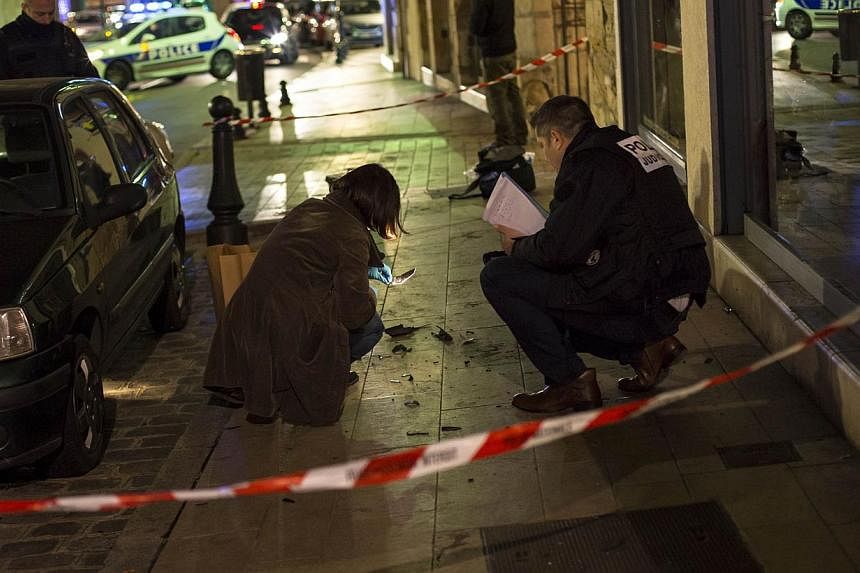 Policemen collect evidence on Dec 21, 2014 in Dijon on the site where a driver shouting "Allahu Akbar" (God is great) ploughed into a crowd injuring 11 people, two seriously, a source close to the investigation said. -- PHOTO: AFP