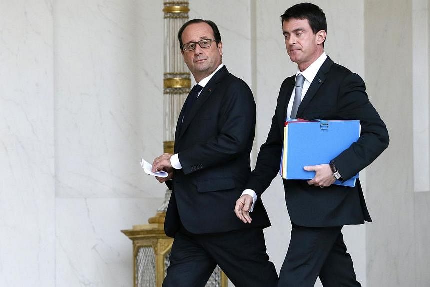 French President François Hollande (left) and French Prime Minister Manuel Valls leave the Elysee Palace after the weekly cabinet meeting on Dec 22, 2014 in Paris. -- PHOTO: AFP
