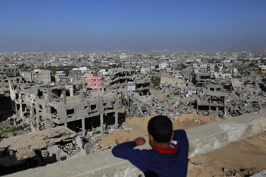 A Palestinian youth looks at rubble of houses which were damaged during the 50-day Gaza war between Israel and Hamas-led militants on Dec 10, 2014 in Gaza City. -- PHOTO: AFP