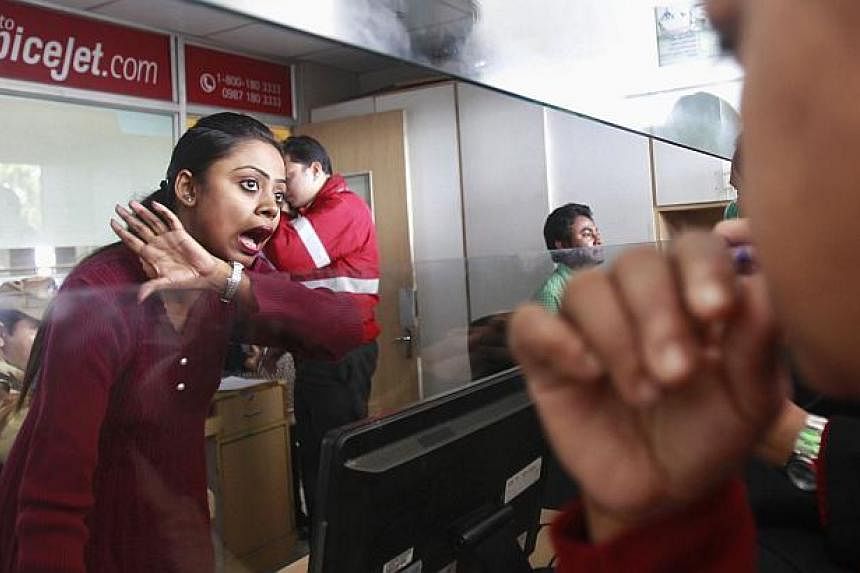 An employee of SpiceJet Airlines speaks with a passenger at the ticket counter at an airport on the outskirts of Agartala, capital of India's northeastern state of Tripura on Dec 17, 2014. -- PHOTO: REUTERS