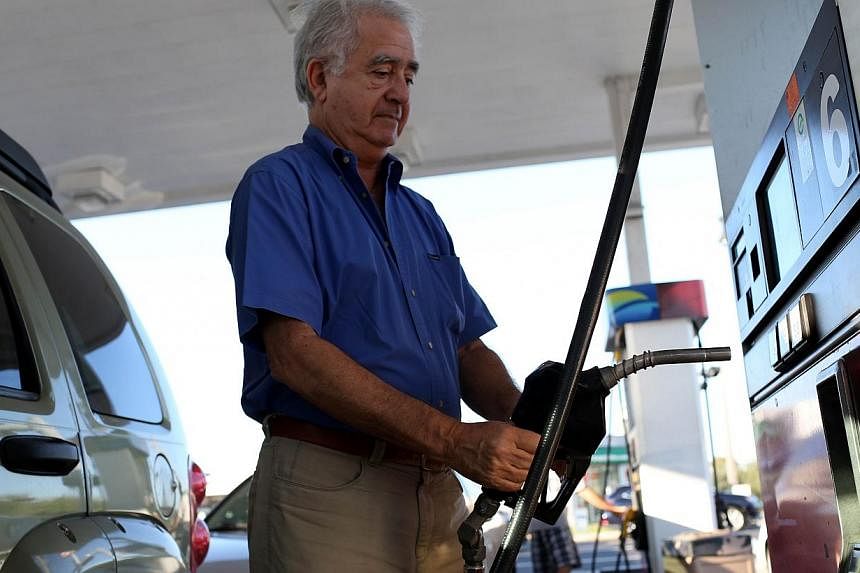 A customer puts petrol into a vehicle at the U-gas station in Miami, Florida earlier this month. -- PHOTO: AFP