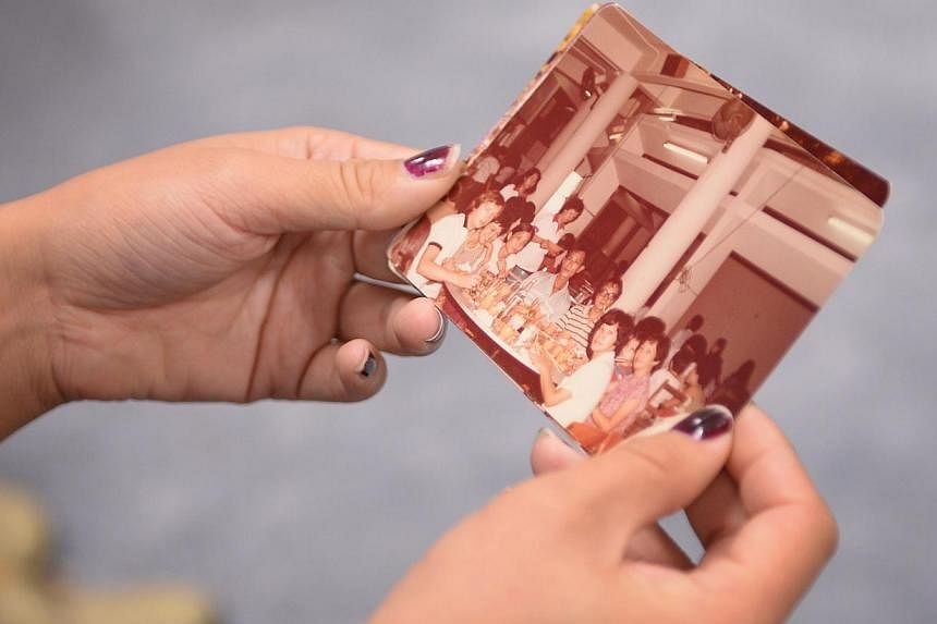 Ms Turzynski holding an old photograph that had her late mother, Madam Lee Kui Yin, in it. (From left) Polish orphan Colleen Turzynski, her aunt Lee Say Moi, Mr Lim Chin Heng, and from the Singapore Association for the Deaf, senior manager Neo Hock S