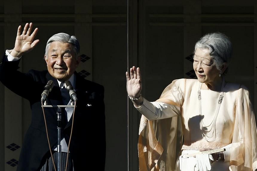 Japan's Emperor Akihito (left) stands next to Empress Michiko (right) as they wave to well-wishers gathered to celebrate his 81st birthday at the Imperial Palace in Tokyo on Dec 23, 2014. -- PHOTO: REUTERS&nbsp;