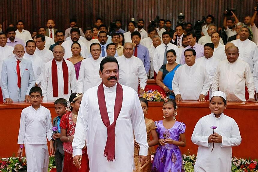 In this handout photograph released by the Sri Lankan Presidential Office, Sri Lankan President Mahinda Rajapakse (centre) is pictured as he unveils his manifesto for the January 2015 presidential election in Colombo on Dec 23, 2014. -- PHOTO: AFP