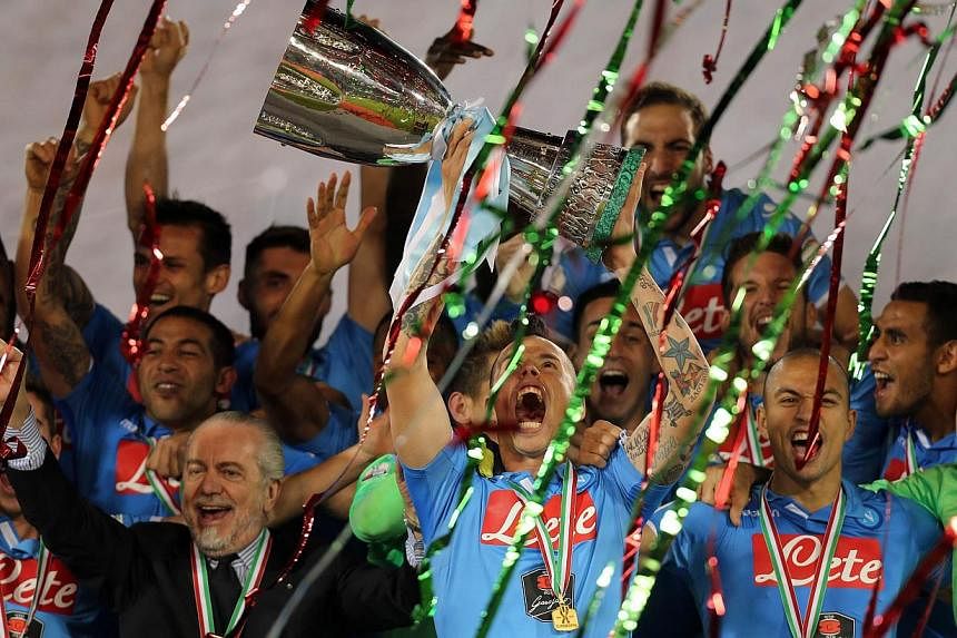 Napoli's Slovak midfielder and captain Marek Hamsik lifting the Italian Super Cup trophy after defeating Serie A champions Juventus at the Sheikh Jassim Bin Hamad Stadium in the Qatari capital Doha on Dec 22, 2014. -- PHOTO: AFP