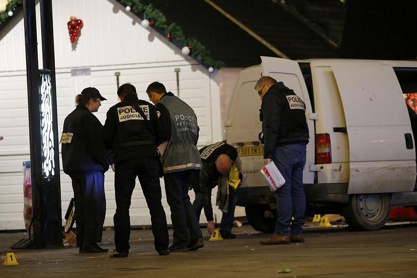 French police investigators work near a van which was driven into a crowd, injuring ten people, including five seriously wounded, according to French media, in Nantes on Monday. Five people including the driver suffered serious injuries and one of th