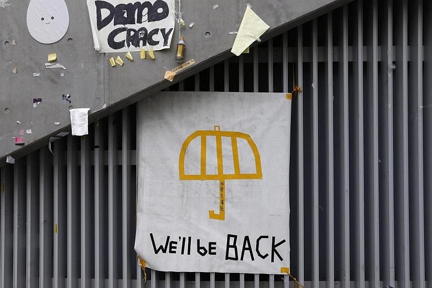A poster of an umbrella with the words "We'll be back" written underneath is pictured on a wall at the main "Occupy" protest site at Admiralty in Hong Kong on Dec 11, 2014.&nbsp;Hong Kong's pro-democracy protest camps may have been swept away but one
