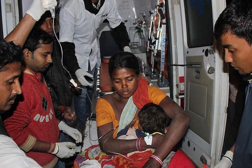 An injured women and her child arrive at a hospital in the Sonitpur district of Assam on Dec 23, 2014. -- PHOTO: AFP