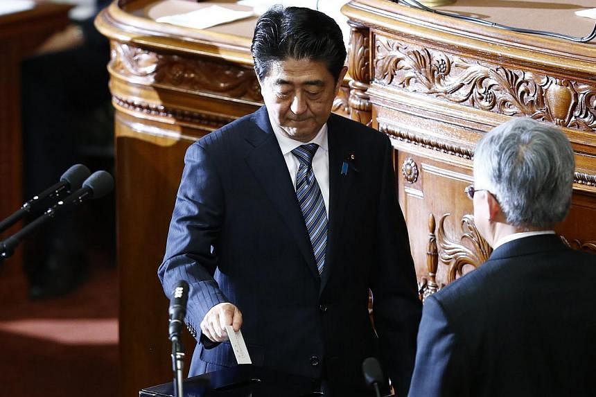 Japan's Prime Minister Shinzo Abe casts a vote at the Lower House of the Parliament in Tokyo on Dec 24, 2014. -- PHOTO: REUTERS
