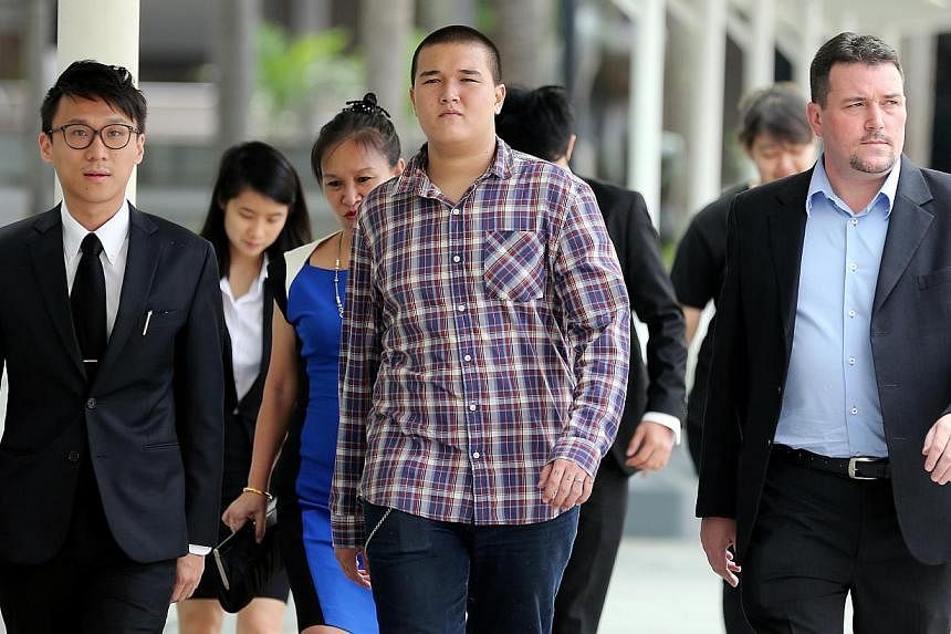 David William Graaskov (center) and his parents and lawyers arriving at the State Courts. The teenager is accused of conspiring with four others to commit vandalism at the rooftop of a HDB block in Toa Payoh on May 7, 2014. He also removed a reflecti