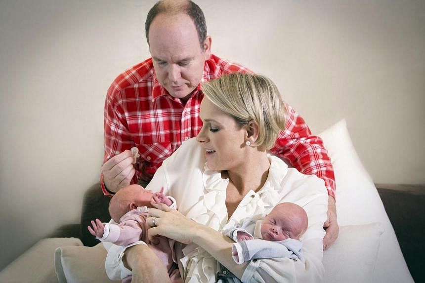 A handout picture released by the Palace of Monaco on Dec 23, 2014 shows Prince Albert II of Monaco and his wife Charlene posing with their twin babies Jacques and Gabriella at the Princess Grace Hospital in Monaco on Dec 22, 2014. -- PHOTO: AFP