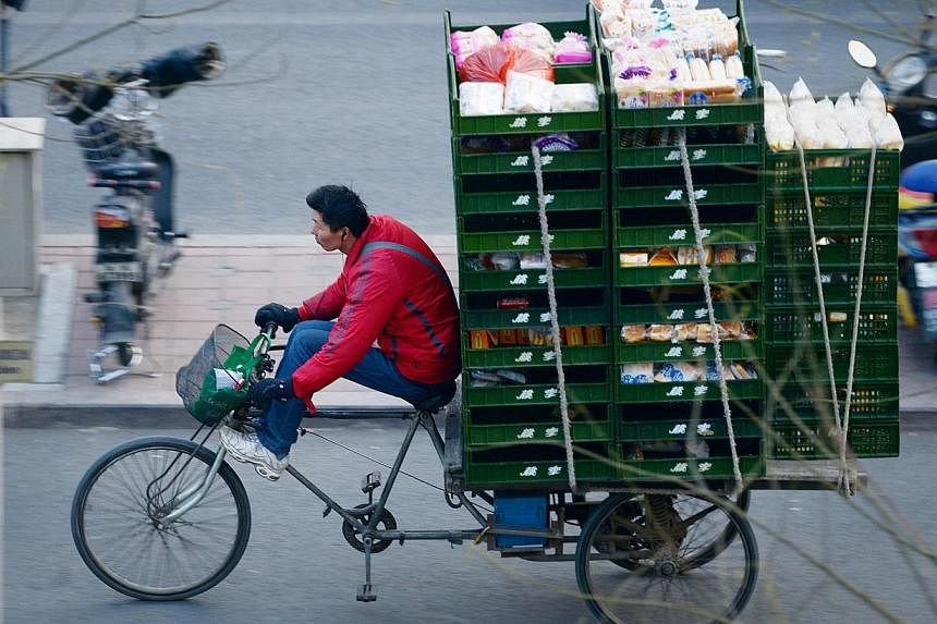 A vendor rides a loaded tricycle along a street in Beijing on Dec 8, 2014.&nbsp;China's economy is creating more than 13 million new jobs this year, the Xinhua news agency cited the labour ministry as saying on Thursday, outstripping the official tar