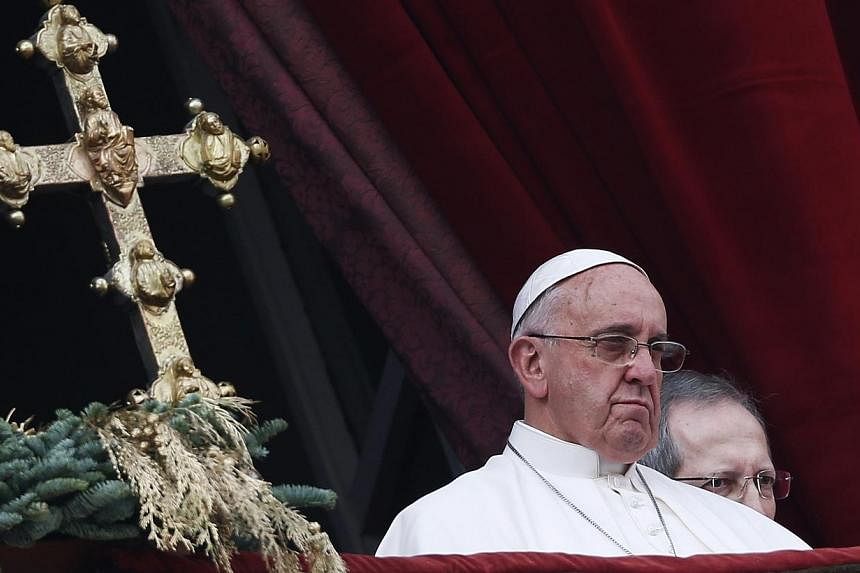 Pope Francis delivers a "Urbi et Orbi" (to the city and world) message from the balcony overlooking St. Peter's Square at the Vatican on Dec 25, 2014. -- PHOTO: REUTERS