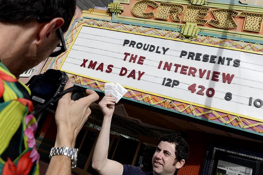 Tickets for the film The Interview is seen held up by theatre manager Donald Melancon for the media at Crest Theater in Los Angeles, California Dec 24, 2014. -- PHOTO:&nbsp;REUTERS