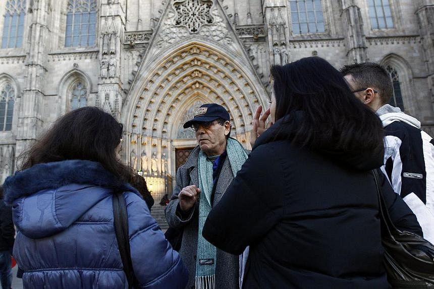 Ramon Holgado (center) conducts a tour for Barcelona Hidden City Tours, a startup company which offers homeless people a job as tour guides in Barcelona. -- PHOTO: AFP&nbsp;