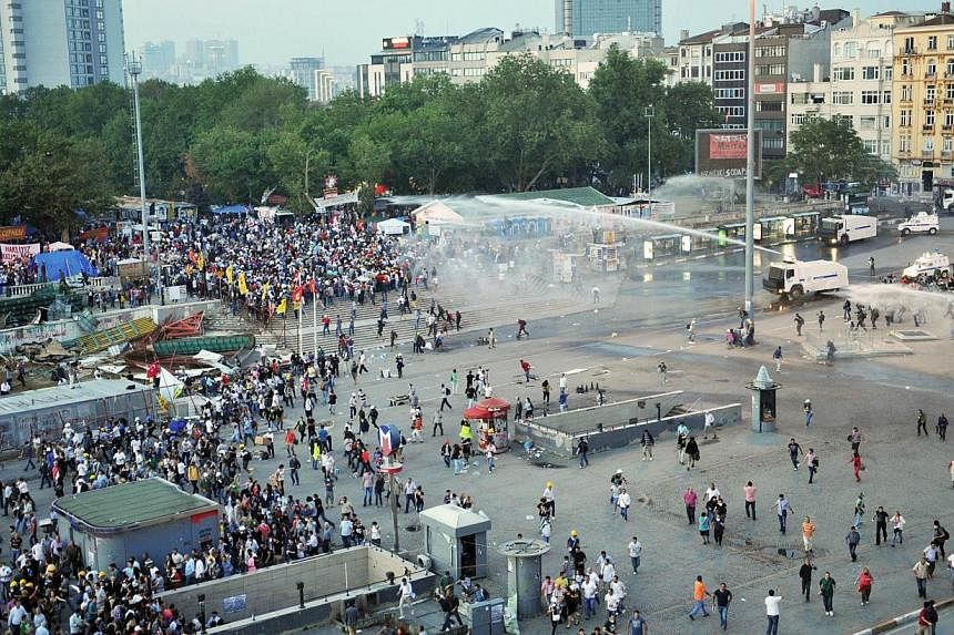 A picture taken on June 15, 2013 shows riot police using a water cannon and tear gas to disperse protesters at Gezi Park near Taksim Square in Istanbul.&nbsp;A Turkish teenager who survived a severe head injury inflicted by the police in last year's 