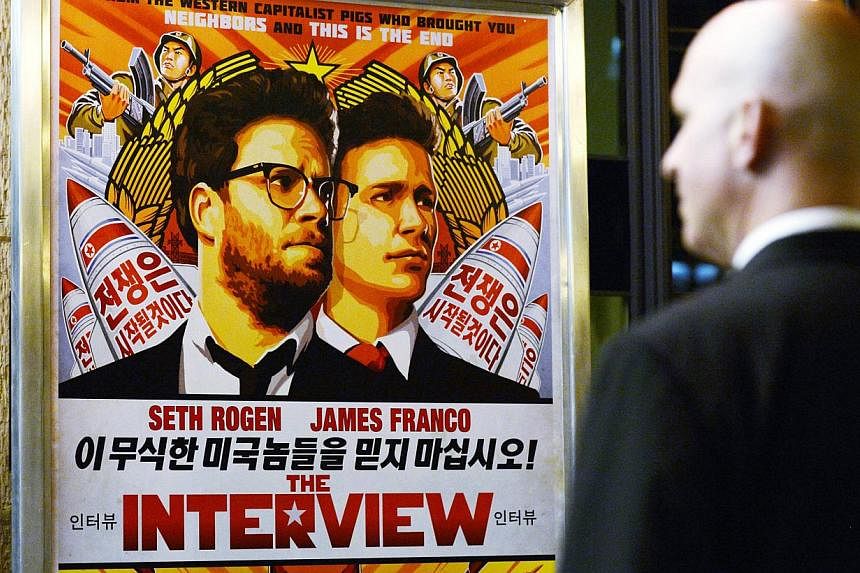 A security guard checks out a poster for the movie The Interview at a cinema in Los Angeles, California, in this Dec 11, 2014 file photo.&nbsp;Sony Pictures said it will make the comedy movie, The Interview, available for rental and purchase online o
