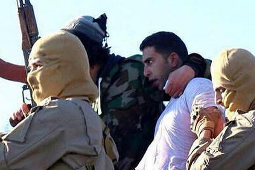 A still image released by the Islamic State group's branch in Raqa on extremist websites on Dec 24, 2014 purportedly shows a Jordanian pilot captured by Islamic State in Iraq and Syria group fighters after they shot down a warplane from the US-led co
