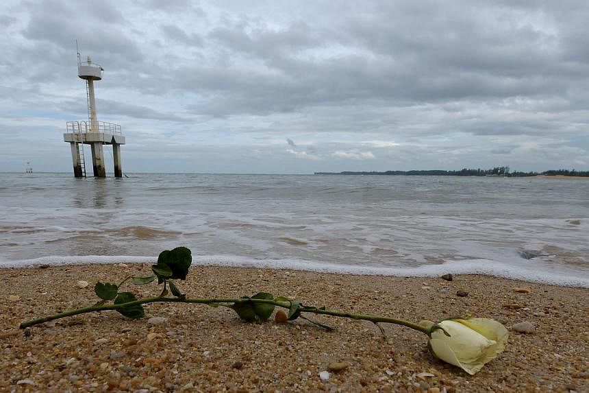A rose sits on the beach near the Ban Nam Khem tsunami memorial park wall as the tenth anniversary of the 2004 tsunami is remembered in Phang-nga province on Dec 26, 2014. -- PHOTO: AFP