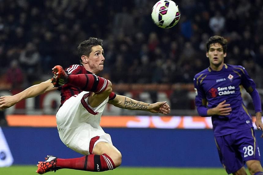 AC Milan's forward from Spain Fernando Torres (left) takes a shot during the Italian Serie A football match at the San Siro Stadium stadium in Milan on Oct 26, 2014. -- PHOTO: AFP