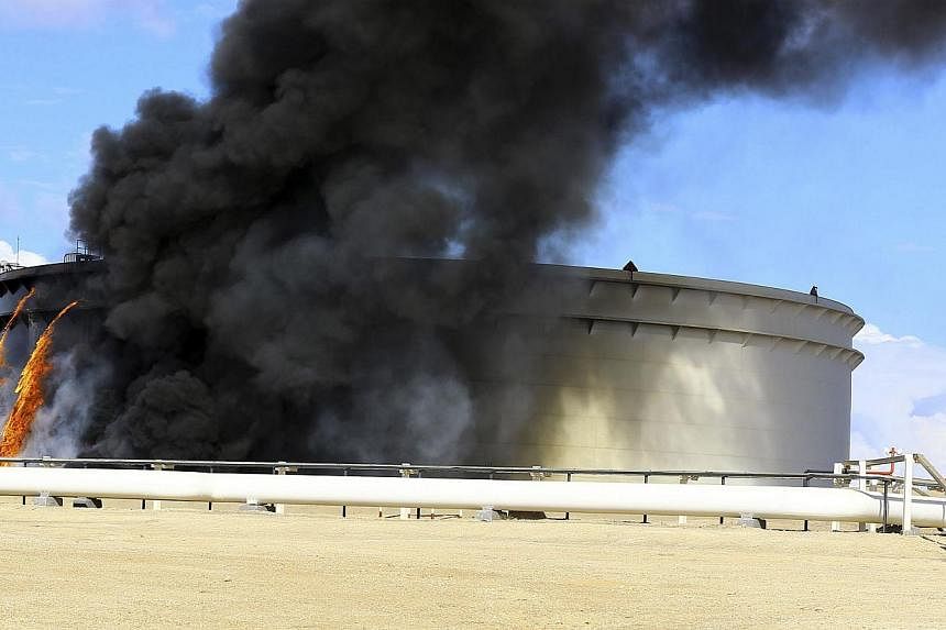 Black smoke billowing out of a storage oil tank in the port of Es Sider in Ras Lanuf on Dec 25, 2014. A rocket hit the storage tank in the eastern Libyan oil of port Es Sider as armed factions allied to competing governments fought for control of the