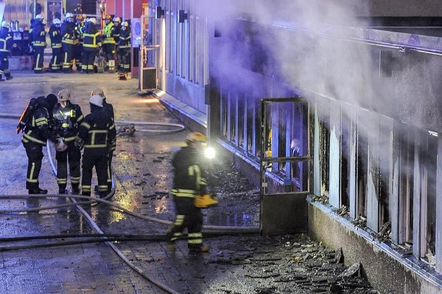 Smoke rises from the interior of a destroyed cellar mosque as firefighters search the remains of the building after an arson attack on Dec 25, 2014 in Eskilstuna, central Sweden. -- PHOTO: AFP
