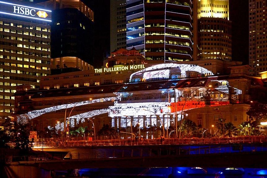 3D projection mapping display of a MRT train on the facade of Fullerton Hotel Singapore on Dec 26, 2014. -- ST PHOTO: LIM SIN THAI