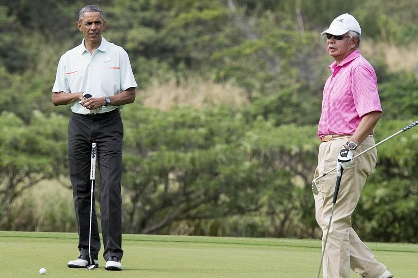 United States President Barack Obama and Malaysian Prime Minister Najib Razzak playing golf at Marine Corps Base Hawaii on Dec 24, 2014. Datuk Seri&nbsp;Najib came under fire after photos showed him golfing with Mr Obama as the country's worst floodi
