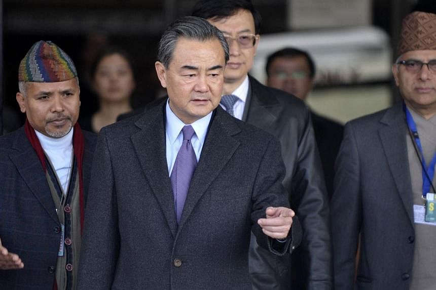 Chinese Foreign Minister Wang Yi (middle) gestures following his arrival at Tribhuvan International Airport in Kathmandu on Dec 25, 2014. -- PHOTO: AFP