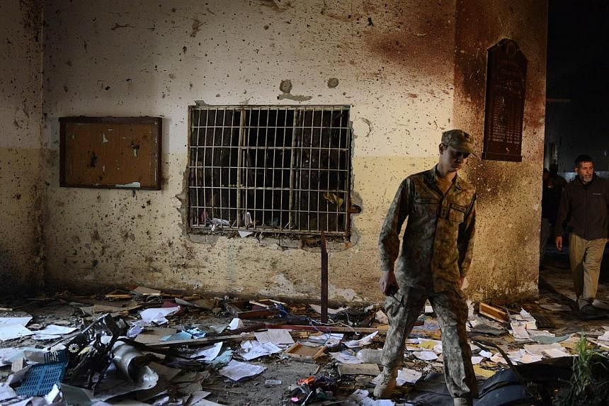 A Pakistani soldier walks amidst the debris in an army-run school a day after an attack by Taleban&nbsp;militants in Peshawar on Dec 17, 2014. -- PHOTO: AFP