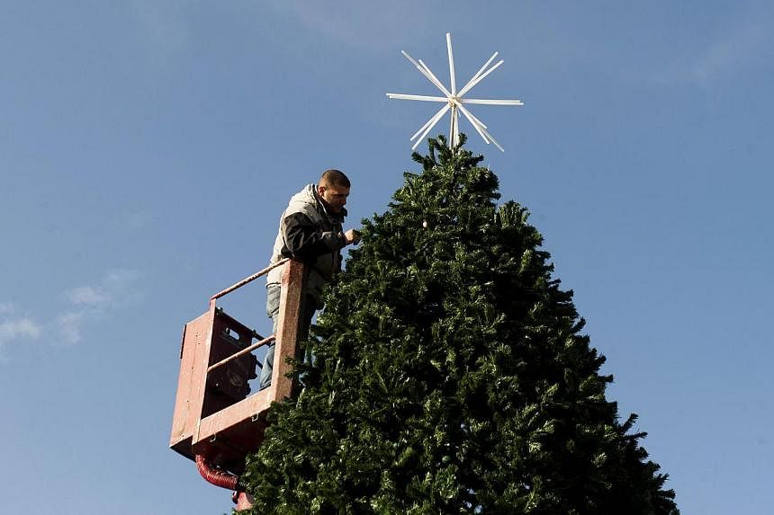 A municiple worker puts the final touches to a Christmas Tree in the main square in Pristina on Dec 20, 2014 ahead of Christmas and New Year celebrations in Kosovo. Kosovo authorities said Friday a potential car bombing was thwarted in Pristina on Ch