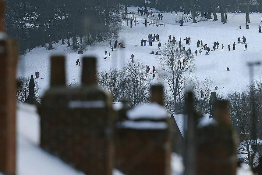 People sledge in a snow covered park in Sheffield, northern England on Dec 27, 2014. &nbsp;- PHOTO: REUTERS