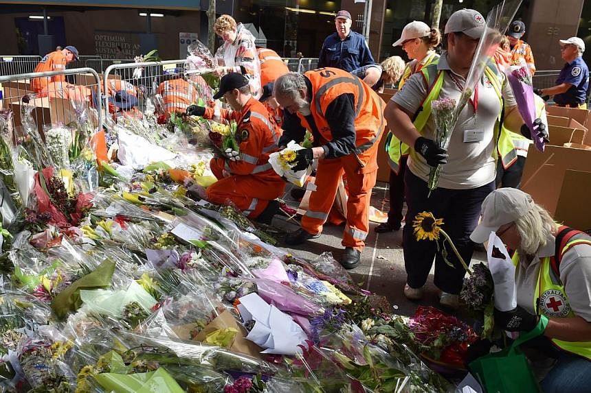 Flowers being removed at a memorial site outside the Lindt cafe in Sydney on Tuesday, one week after the siege which saw two hostages and the gunman killed. What is striking about such incidents is the everyday ordinariness of where the victims were 