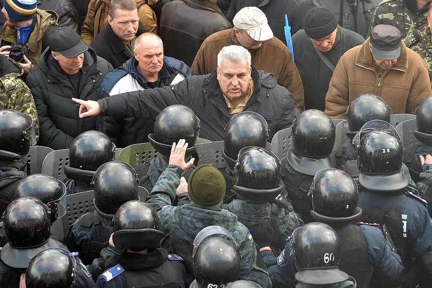 Protesters and police in Kiev, Ukraine. Russian President Vladimir Putin’s revanchism in Ukraine’s Donbas region has a disturbingly familiar ring to it – reminiscent of interwar Germany’s own irredentist policies. -- PHOTO: AGENCE FRANCE-PRES